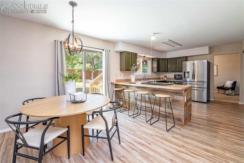 Image 12 of 38: Dining space featuring light wood-style flooring and a chandelier