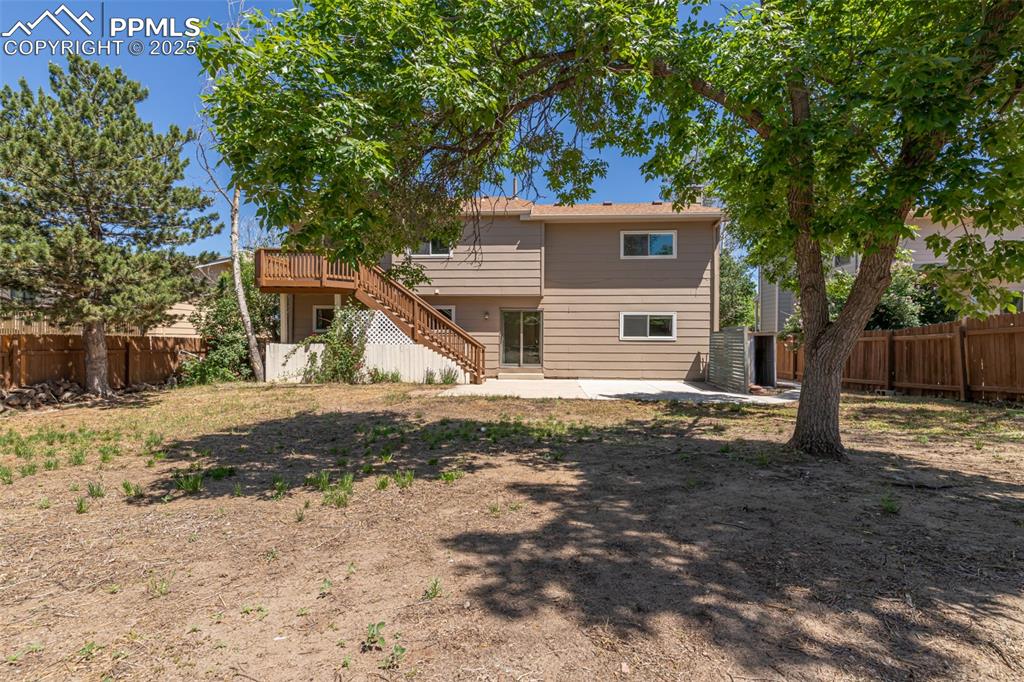 Image 19 of 38: Rear view of house with stairway, a fenced backyard, a patio area, and a de