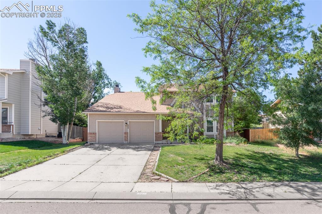 Image 2 of 38: Obstructed view of property with brick siding, driveway, and a garage