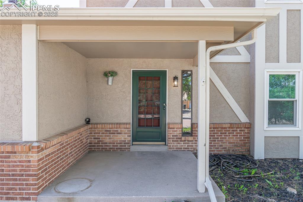 Image 3 of 38: View of exterior entry featuring stucco siding and brick siding