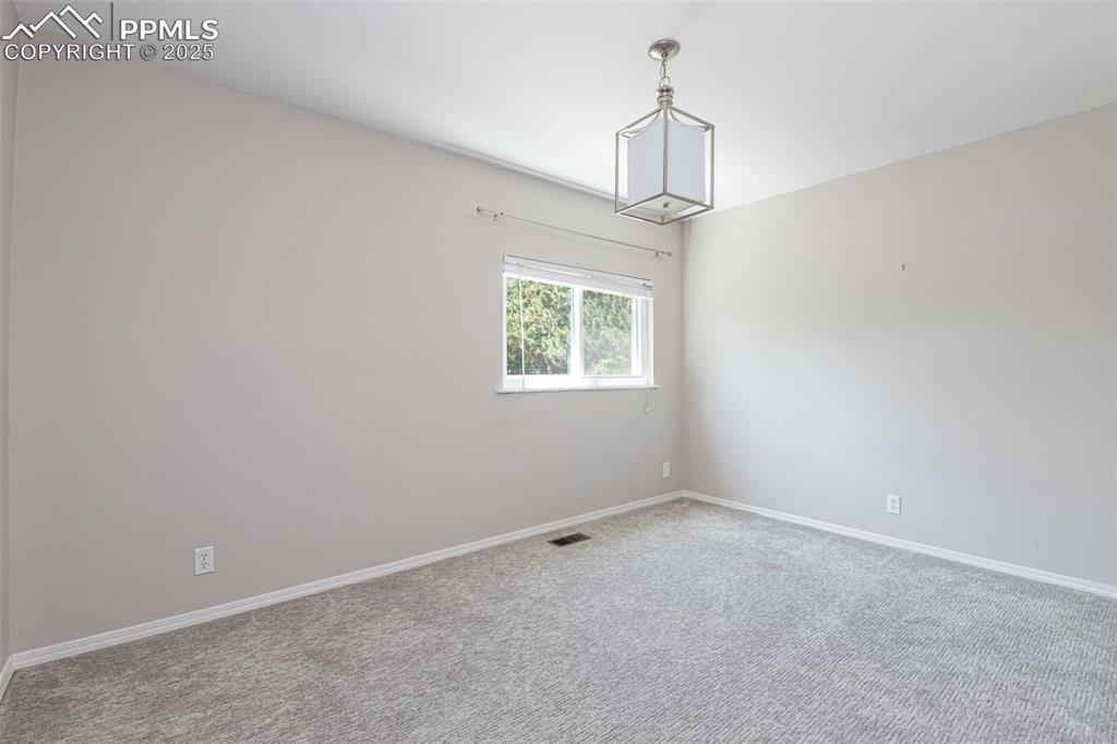 Image 31 of 38: Empty room with carpet floors and baseboards