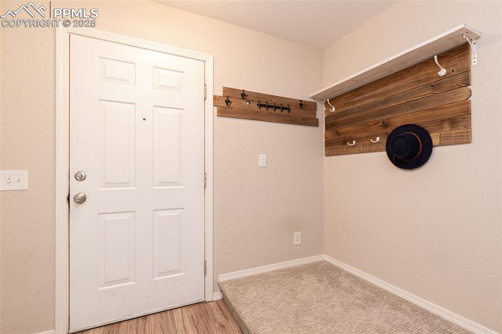 Image 4 of 38: Doorway featuring baseboards and light wood-type flooring