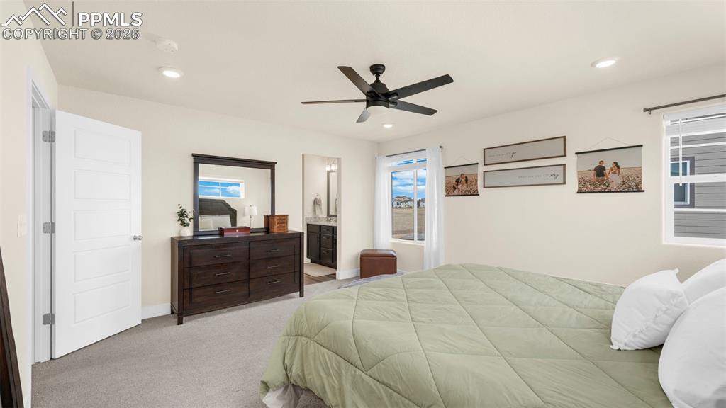 Image 26 of 43: Bedroom with light carpet, ceiling fan, ensuite bath, and recessed lighting