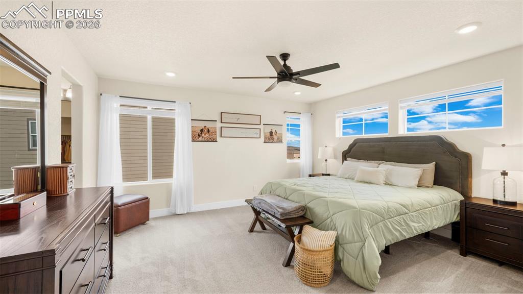 Image 27 of 43: Bedroom with light carpet, ceiling fan, and recessed lighting