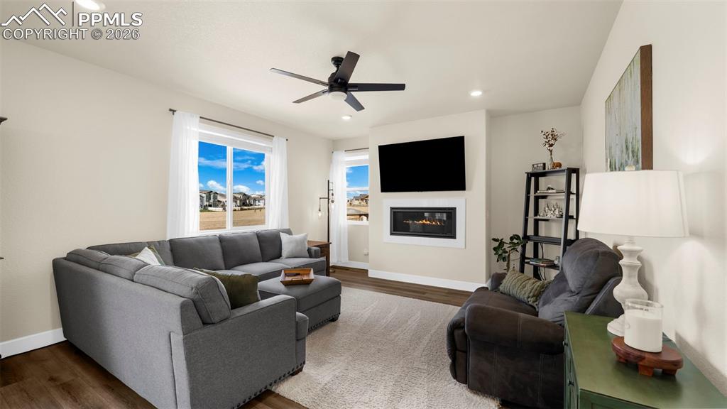 Image 28 of 43: Living room featuring wood finished floors, a glass covered fireplace, ceil