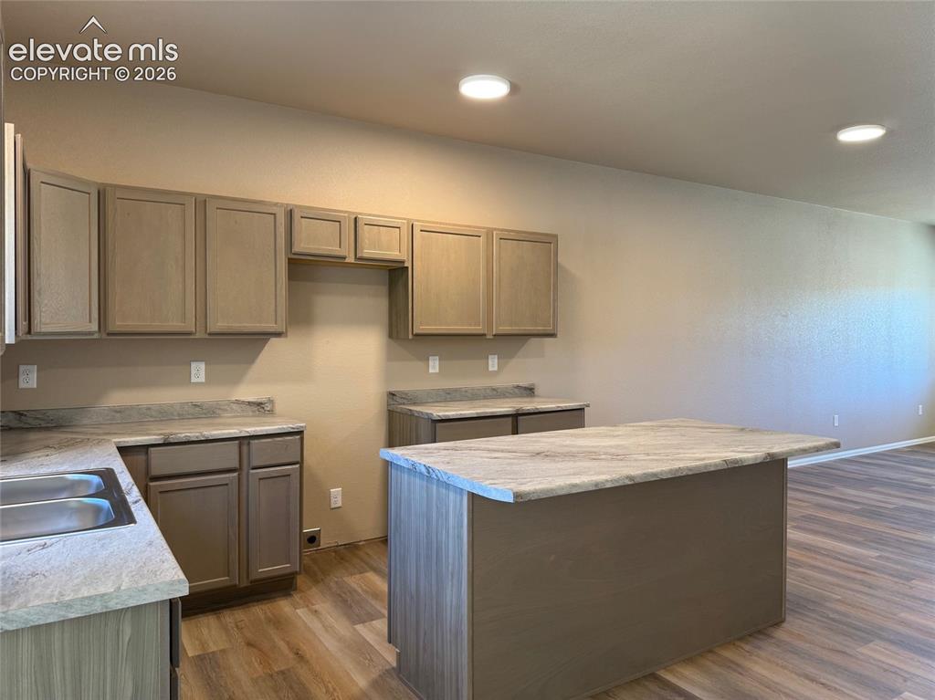 Image 11 of 34: Kitchen featuring wood-finish cabinetry, light-toned countertops, and wood-