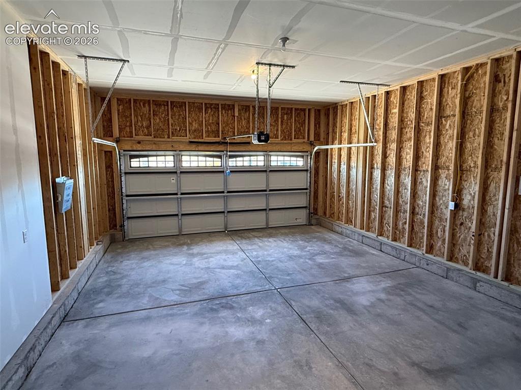 Image 21 of 34: Spacious garage featuring a concrete floor, exposed wood framing, and a seg
