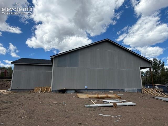 Image 4 of 34: Gabled rooflines with dark shingles, grey vertical panel siding, and an exp