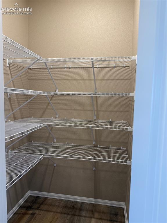 Image 9 of 34: Expansive walk-in pantry with multiple levels of wire shelving and wood-fin