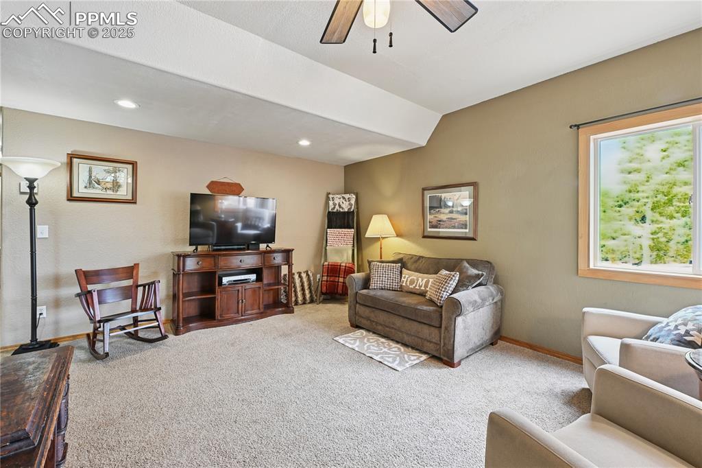 Image 13 of 34: Carpeted living area with ceiling fan and recessed lighting