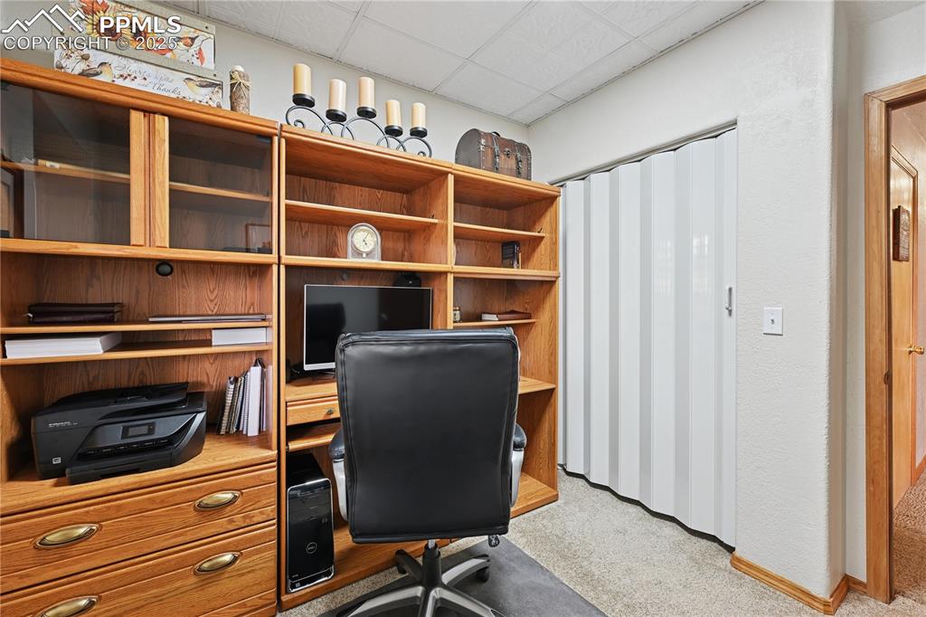 Image 15 of 34: Office area with light carpet and a drop ceiling
