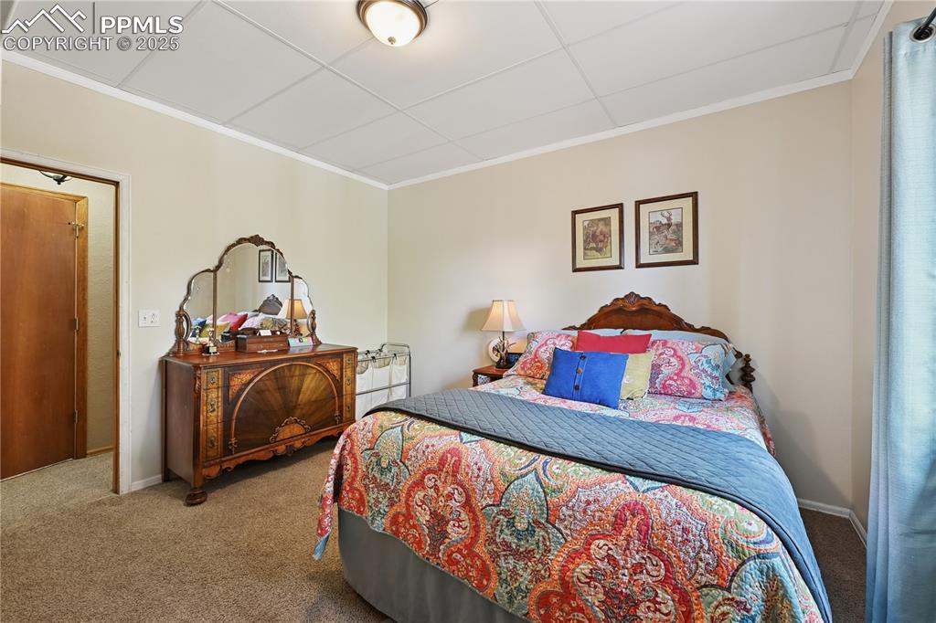Image 17 of 34: Carpeted bedroom featuring crown molding and a drop ceiling