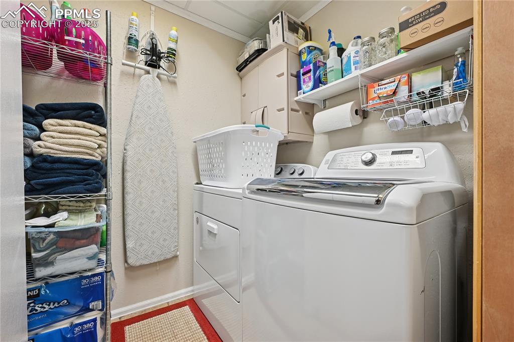 Image 19 of 34: Laundry area featuring washing machine and dryer and cabinet space