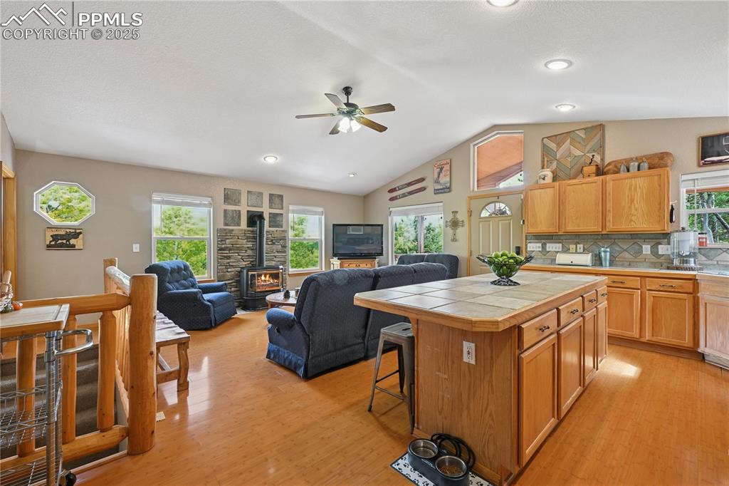Image 27 of 34: Kitchen featuring a gas stove, a kitchen breakfast bar, vaulted ceiling, li