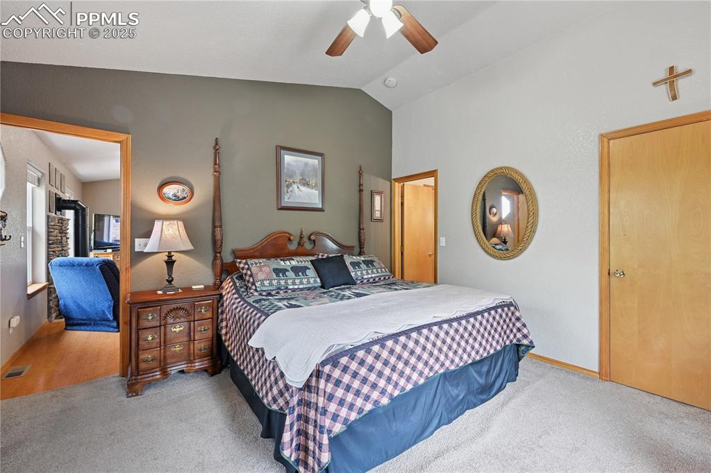 Image 30 of 34: Bedroom with lofted ceiling, a ceiling fan, and carpet flooring