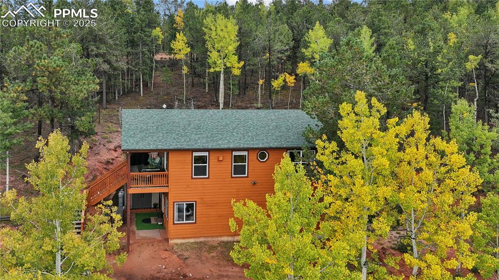 Image 6 of 34: Rustic home featuring a balcony, a shingled roof, and stairway