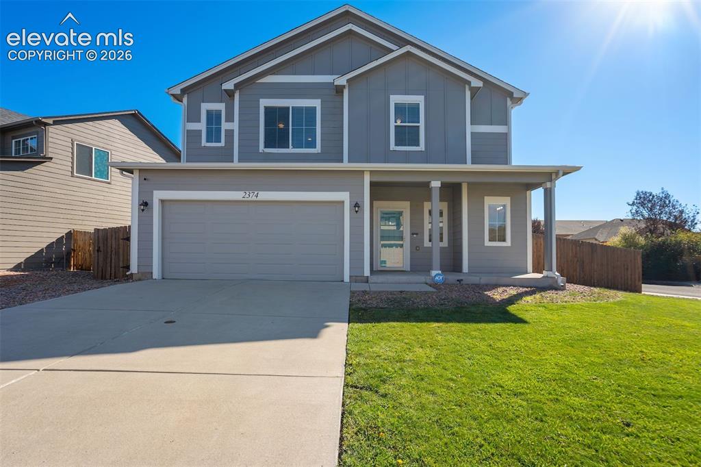 Image 1 of 49: Two-story residence featuring a covered front porch, an attached garage, a
