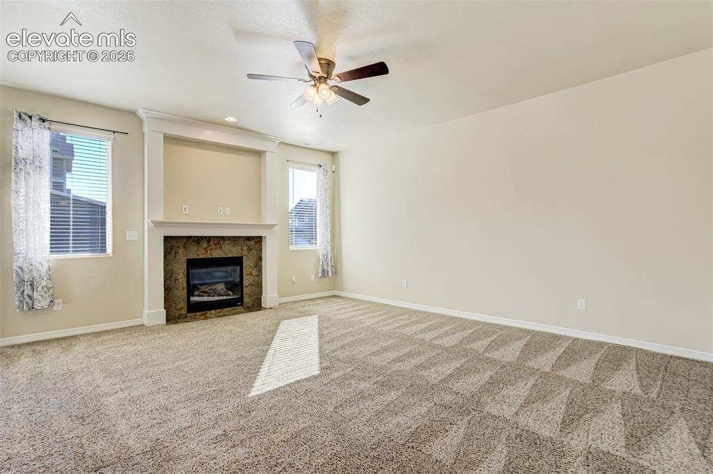 Image 11 of 49: Spacious room featuring, a ceiling fan with integrated lighting, and a ston