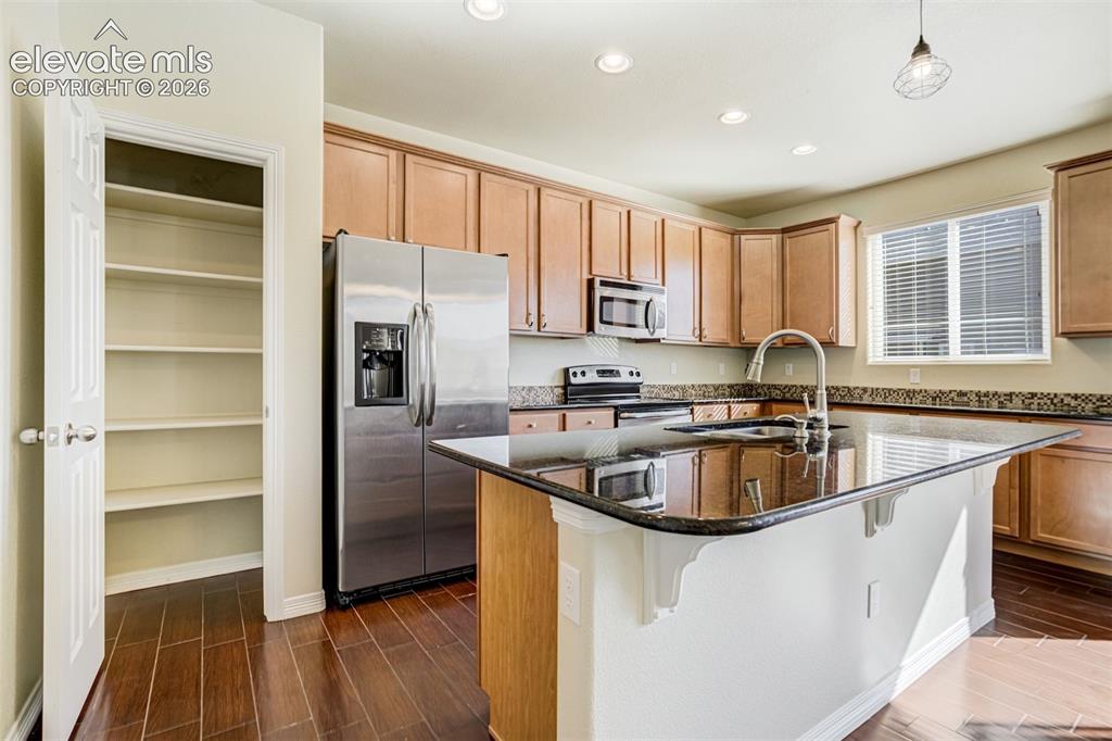 Image 17 of 49: Kitchen featuring wood-finish flooring, recessed lighting, wood cabinetry, 