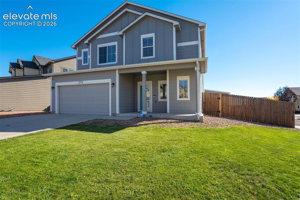 Image 2 of 49: Two-story residence featuring a two-car garage, front porch, and a wood pri