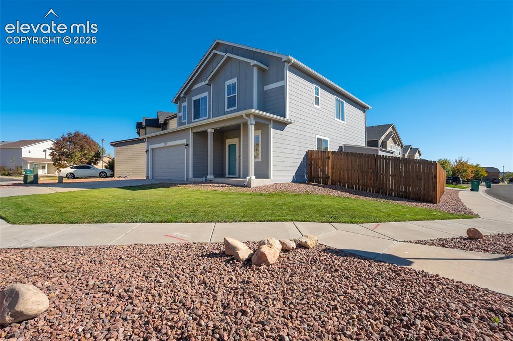 Image 3 of 49: Two-story exterior with light gray siding, an attached two-car garage, a co