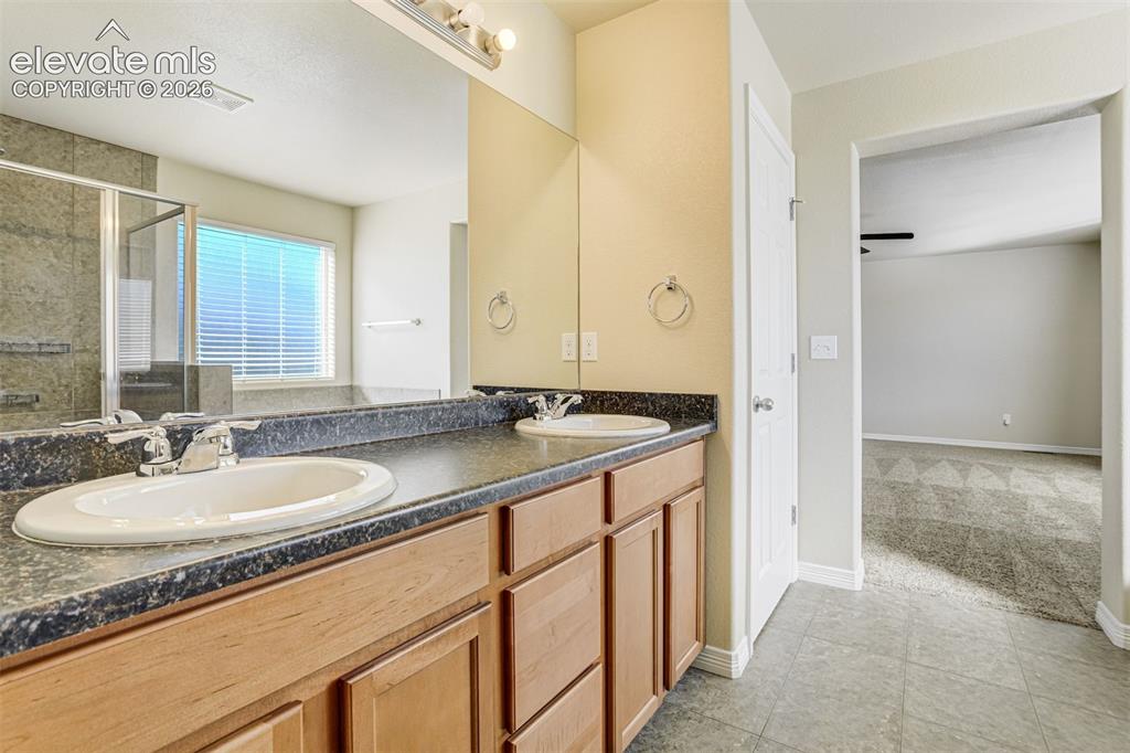 Image 30 of 49: Dual vanity with dark countertops