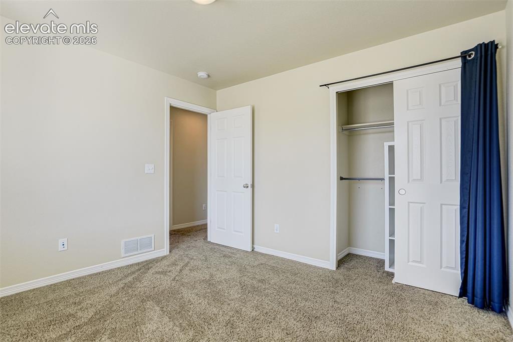 Image 34 of 49: 3rd Bedroom with Carpeted flooring with light-toned walls, a white paneled 