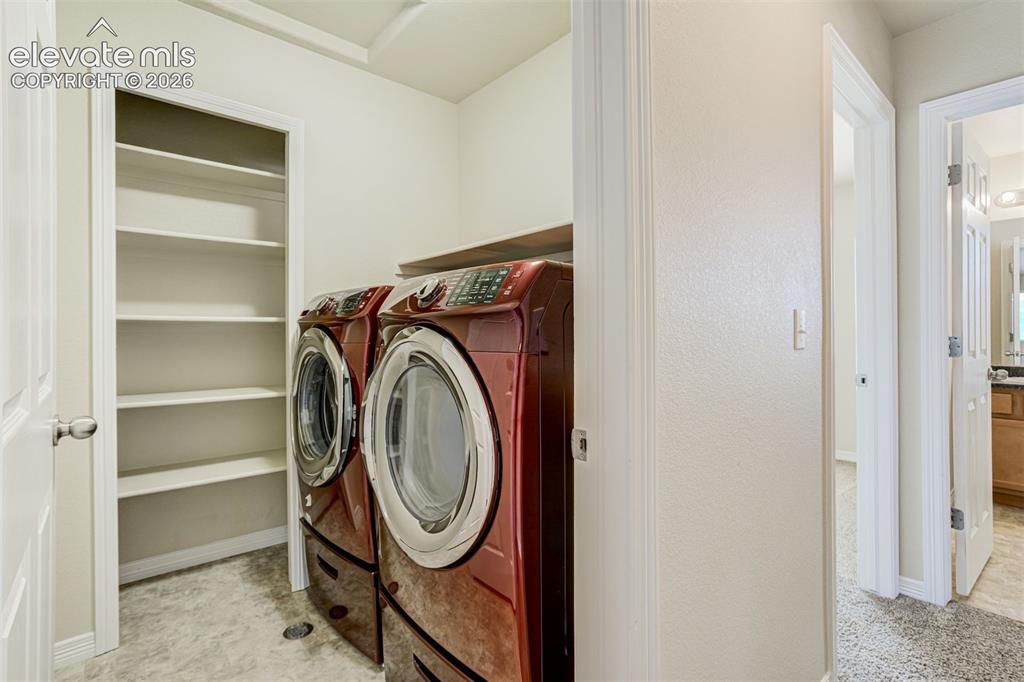Image 37 of 49: Utility room with built-in shelving, a wood-finish counter, and light-toned
