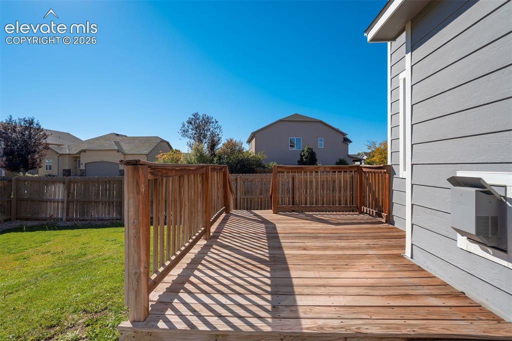 Image 41 of 49: Expansive wood deck with natural wood railing, siding exterior, and a manic