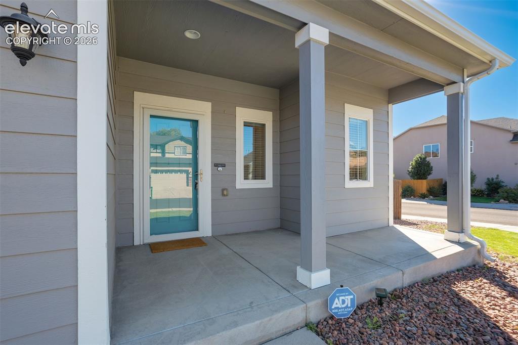 Image 5 of 49: Covered porch with concrete flooring and gray siding