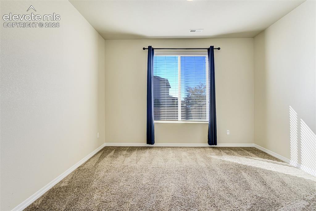 Image 8 of 49: Neutral wall finishes, textured carpeting, window with blinds, and recessed