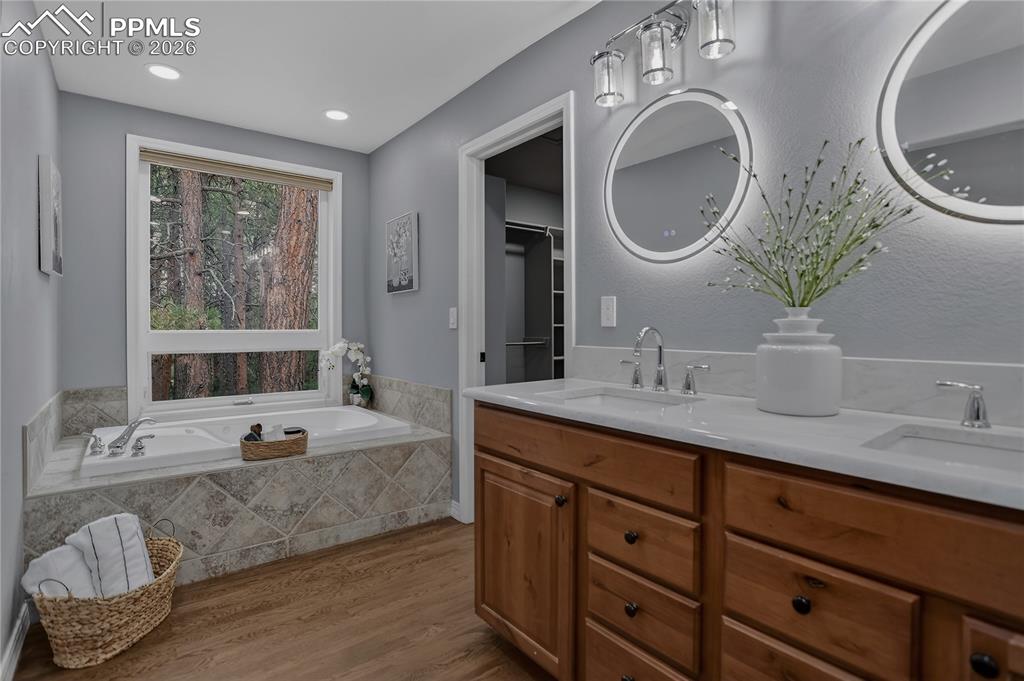 Image 24 of 48: Ensuite primary bath has a jetted tub and dual vanities