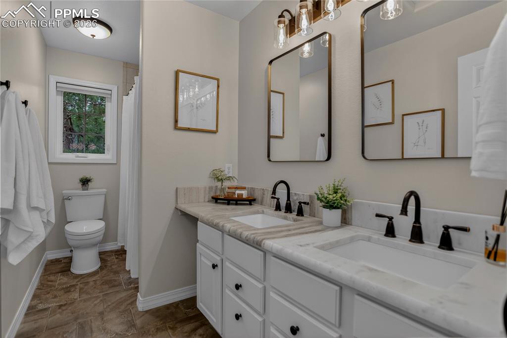 Image 30 of 48: Remodeled upstairs full bath has leather textured countertops and new fixtu