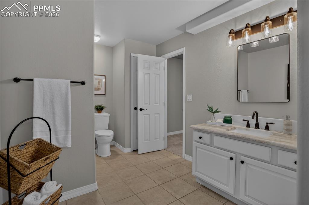 Image 36 of 48: Remodeled lower-level full bath also has leather textured countertops