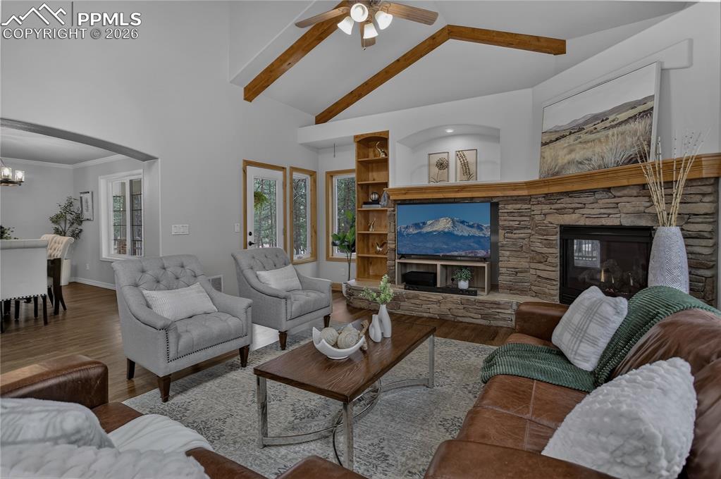 Image 9 of 48: Classic Colorado vibe living room with stone fireplace and built-in shelvin
