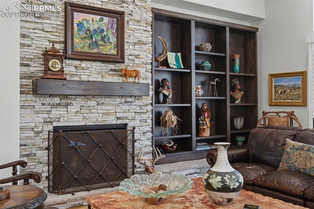 Image 10 of 50: Custom built-in shelving beside the warm gas fireplace offers the perfect c