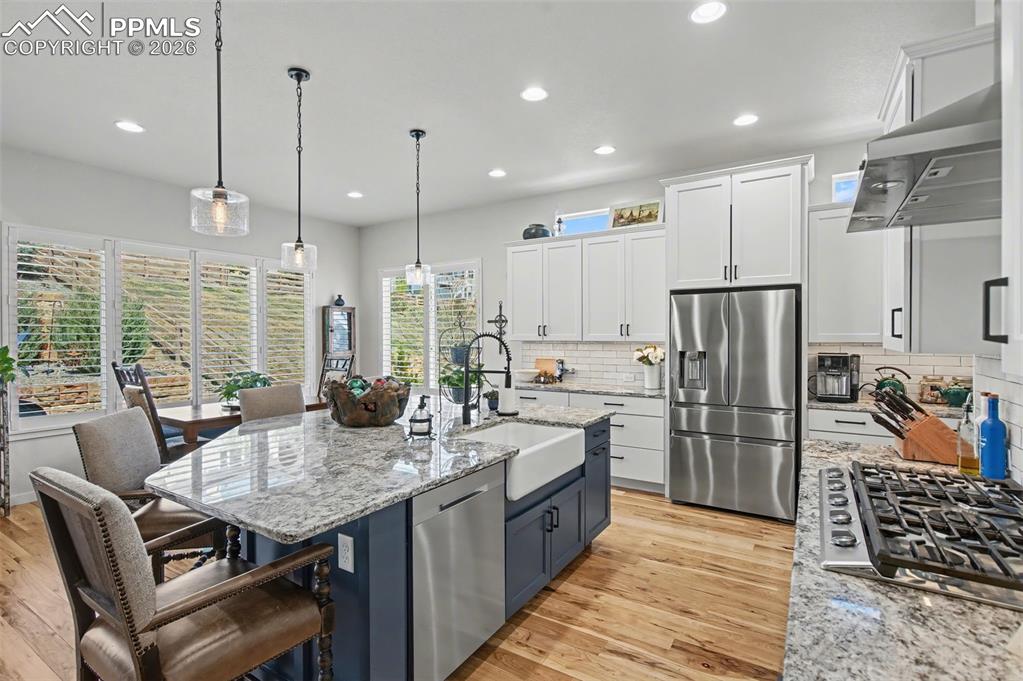 Image 15 of 50: Premium stainless steel appliances and dual pendant lights perfectly comple