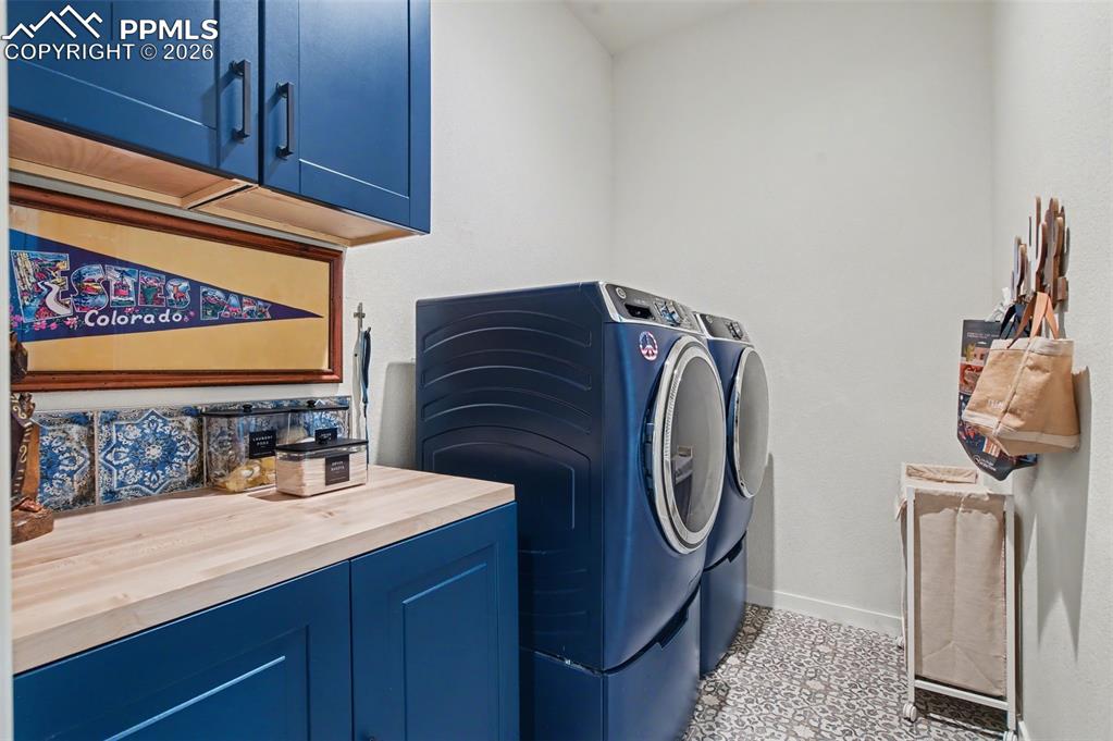Image 21 of 50: This thoughtfully designed laundry space includes ample counter space for f