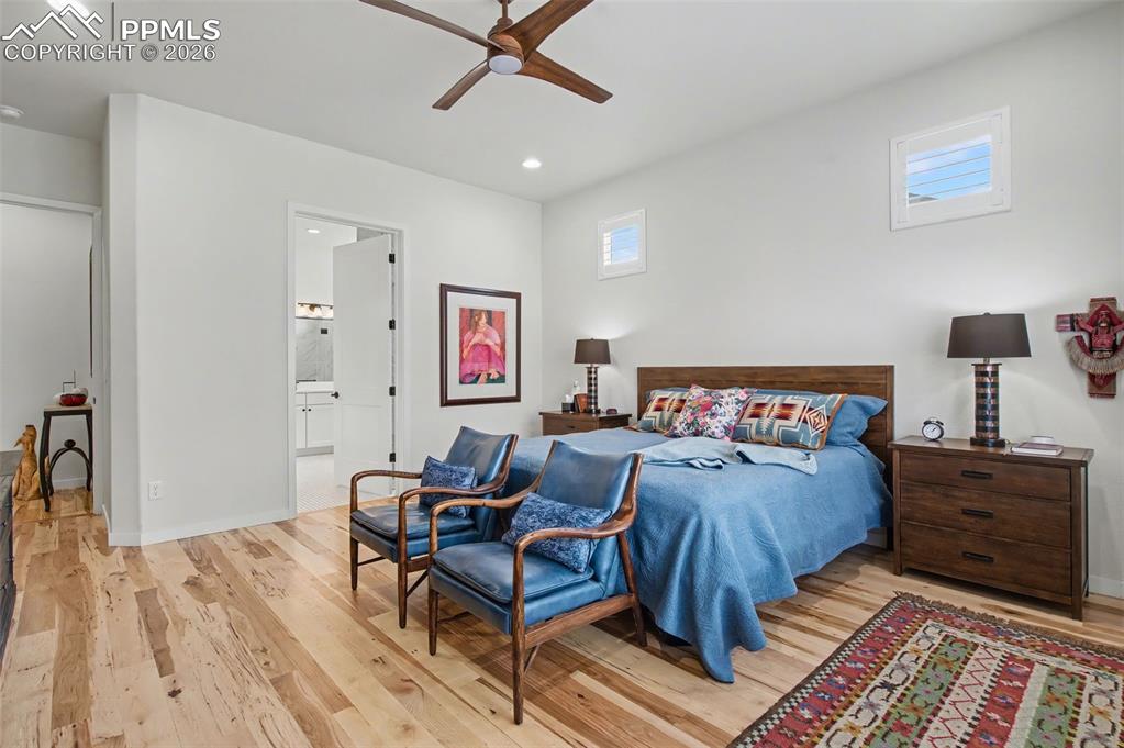 Image 24 of 50: Retreat to the serene primary suite, featuring natural wood floors, plantat