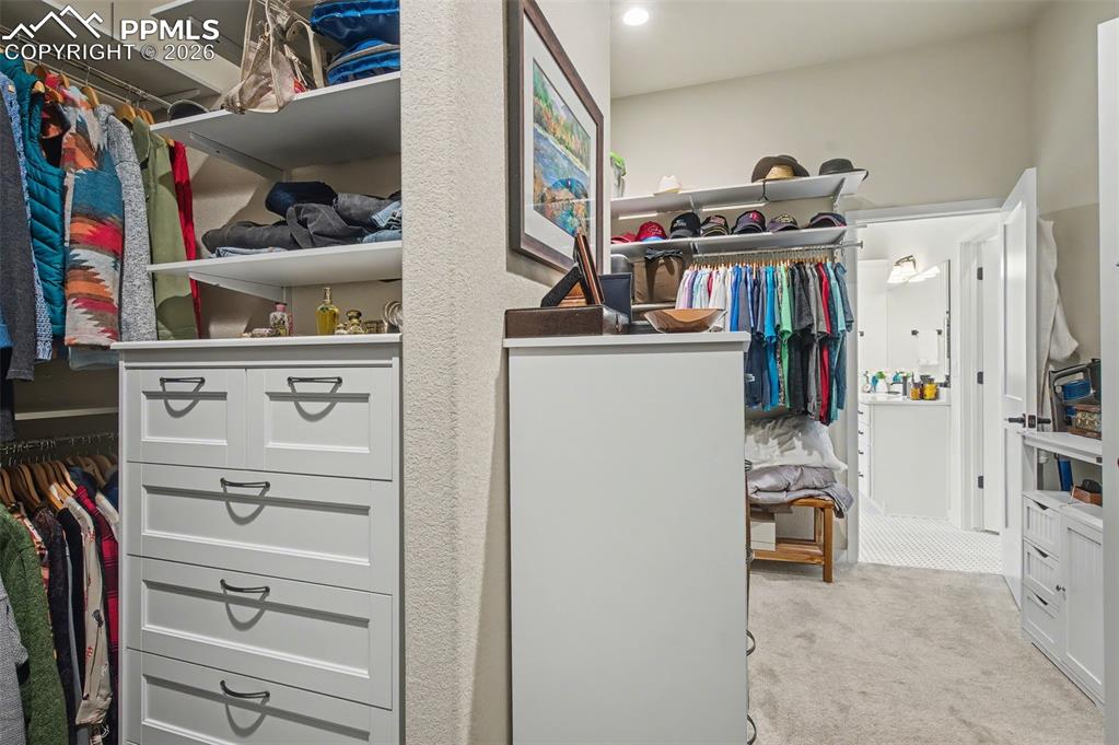 Image 30 of 50: A dedicated dressing area within the primary closet maximizes storage and a