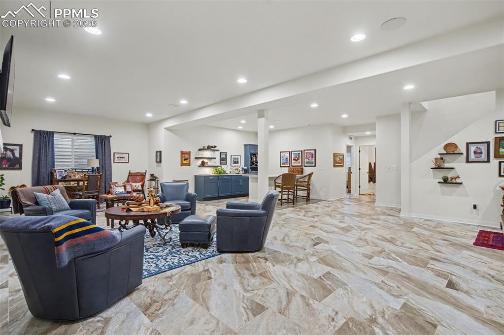 Image 37 of 50: Entertain with ease at the stunning basement wet bar, featuring custom blue