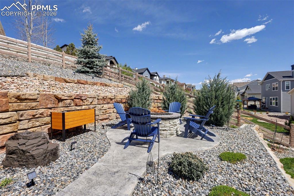 Image 46 of 50: Unwind under the stars at your private built-in fire pit, surrounded by imp