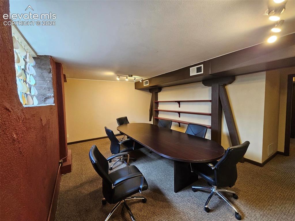 Image 11 of 13: Conference room featuring track lighting, built-in shelving, exposed suppor