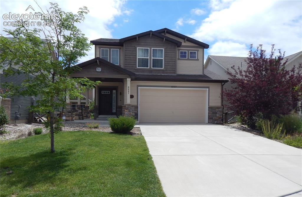 Image 1 of 10: Two-story exterior with a two-car garage, stone accents, and a covered entr