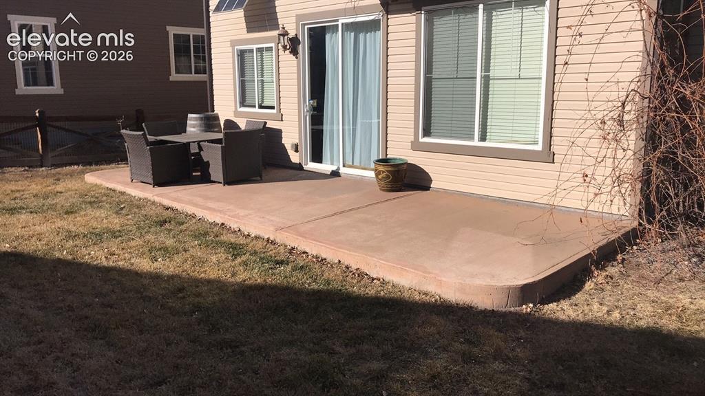 Image 10 of 10: Poured concrete patio with a rounded edge, featuring siding exterior and a 