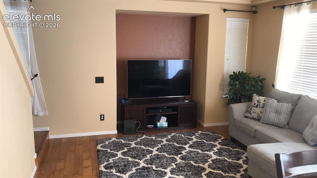 Image 3 of 10: Wood-finish flooring, recessed media niche with accent wall, window blinds,