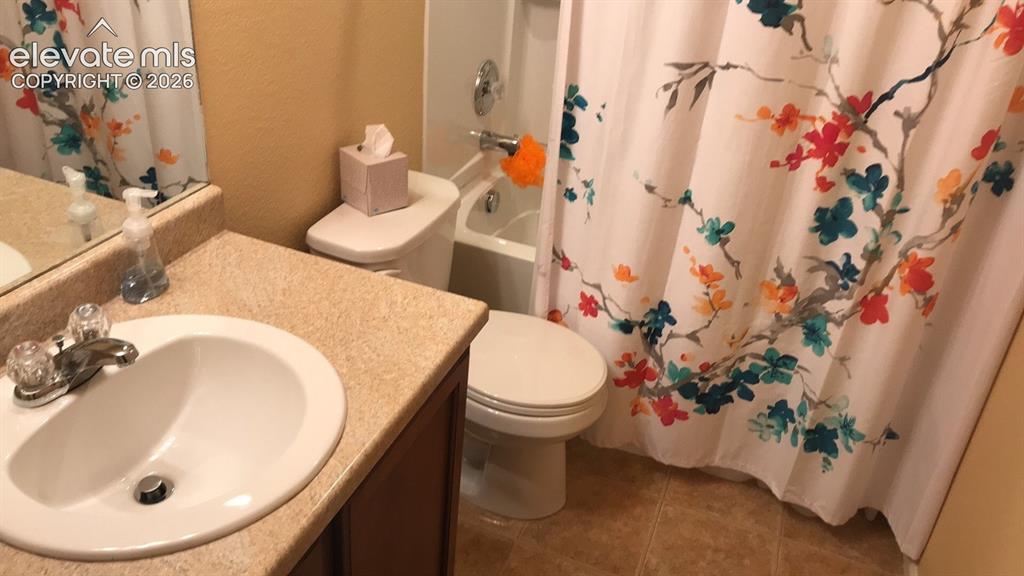 Image 7 of 10: Bathroom featuring a vanity with an integrated sink, a toilet, a shower-tub