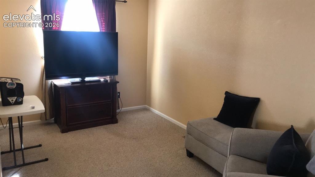 Image 9 of 10: Carpeted flooring, neutral wall tones, and a window with curtain rod