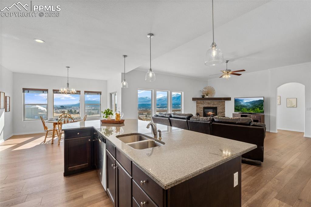 Image 11 of 48: Kitchen with dark wood finish cabinetry, light wood finished floors, a glas