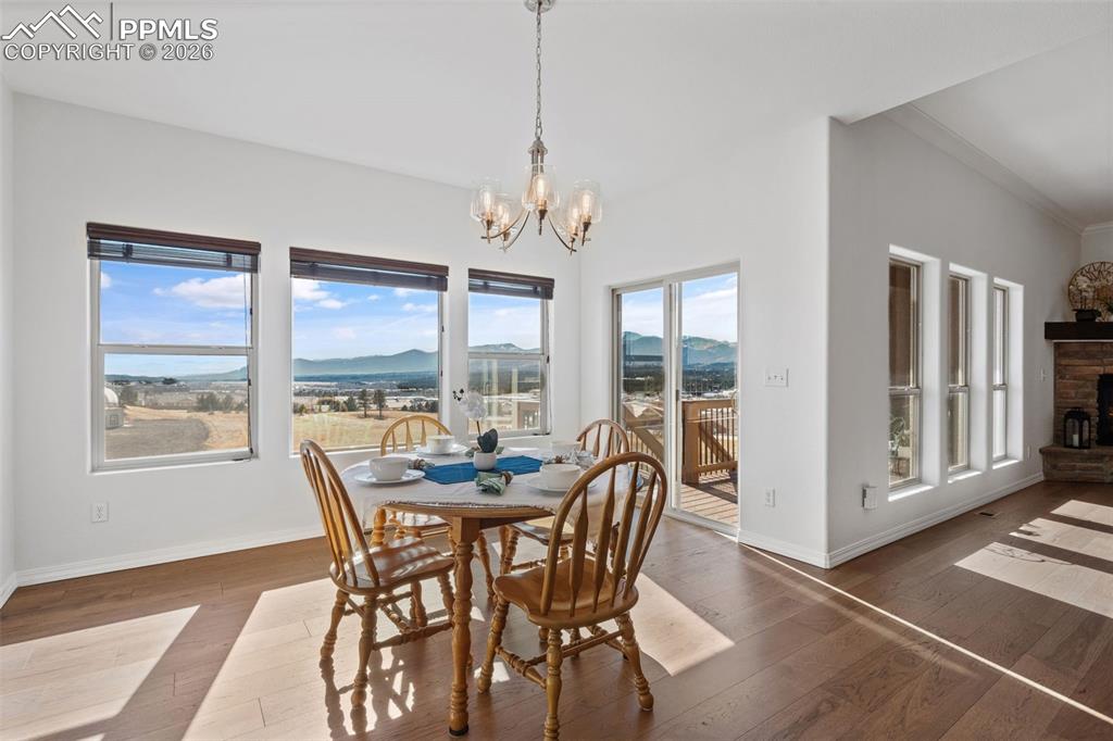 Image 16 of 48: Dining space with a mountain view, a chandelier, a fireplace, crown molding